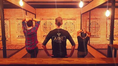 Two people throwing axes at targets