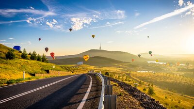 road framed by balloons on horizon