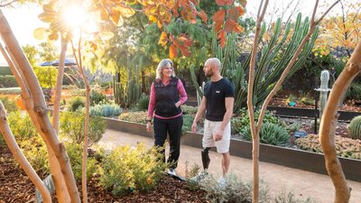 Two people in a garden with with autumn leaves and cacti
