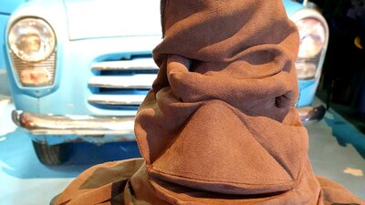 Sorting hat in front of flying car.