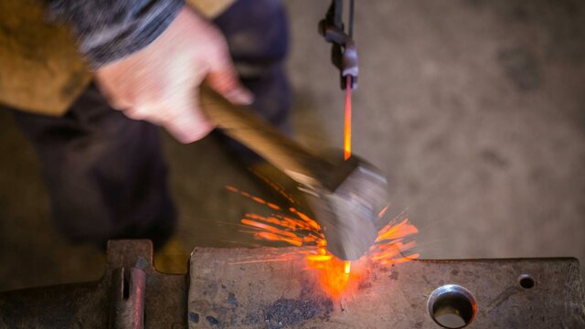You don't need to know how to use tools to enjoy blacksmithing blacksmith striking hot metal on an anvil with sparks flying