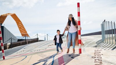 Mum and son holding hand in outside area of National Museum of Australia