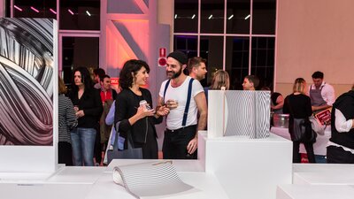 Couple examining a locally designed product at an auction that is part of the Design Canberra program of events.