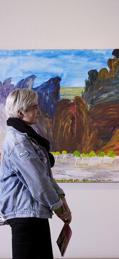 A person walking by an artwork at a gallery