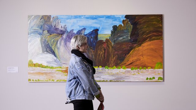 A person walking by an artwork at a gallery