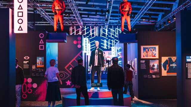 A colourful exhibition gallery space with costumes from Korean entertainment