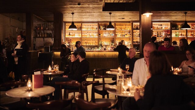 Dimly lit, cosy bar interior with seated patrons