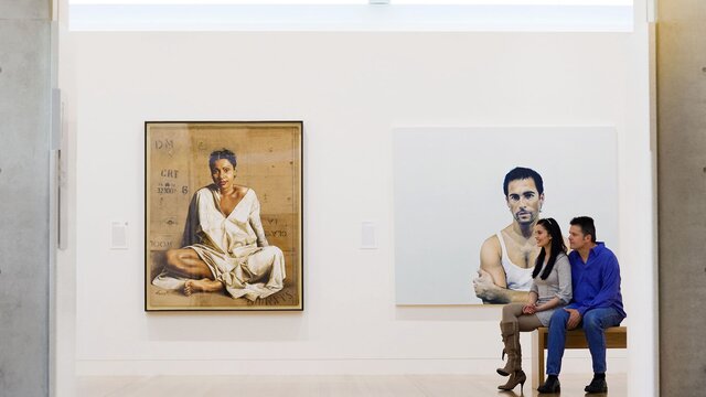 A couple sitting on a bench and admiring the portraits at the National Portrait Gallery.