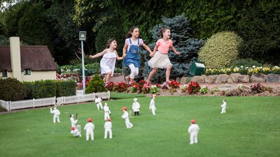Children playing and running amongst the miniature sculptures and displays at Cockington Green.
