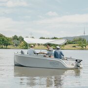 Three friends enjoying a beverage on a boat.