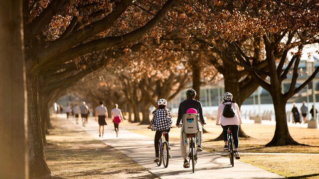 A family enjoying the lakeside and cycling along a path in autumn.