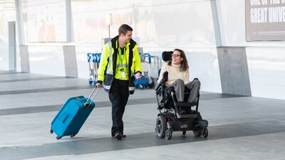 A wheelchair user being supported through their journey around Canberra Airport.