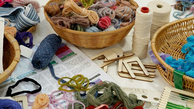Photo courtesy of Australian Tapestry Workshop A table covered in weaving equipment and yarn