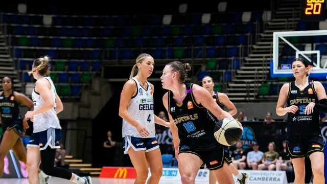 UC Capitals player driving to the basket for a layup during a WNBL game.