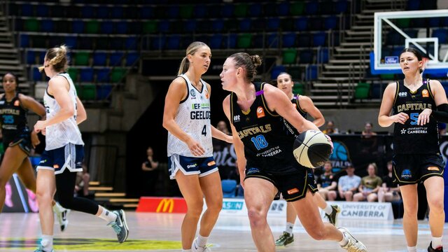 UC Capitals player driving to the basket for a layup during a WNBL game.